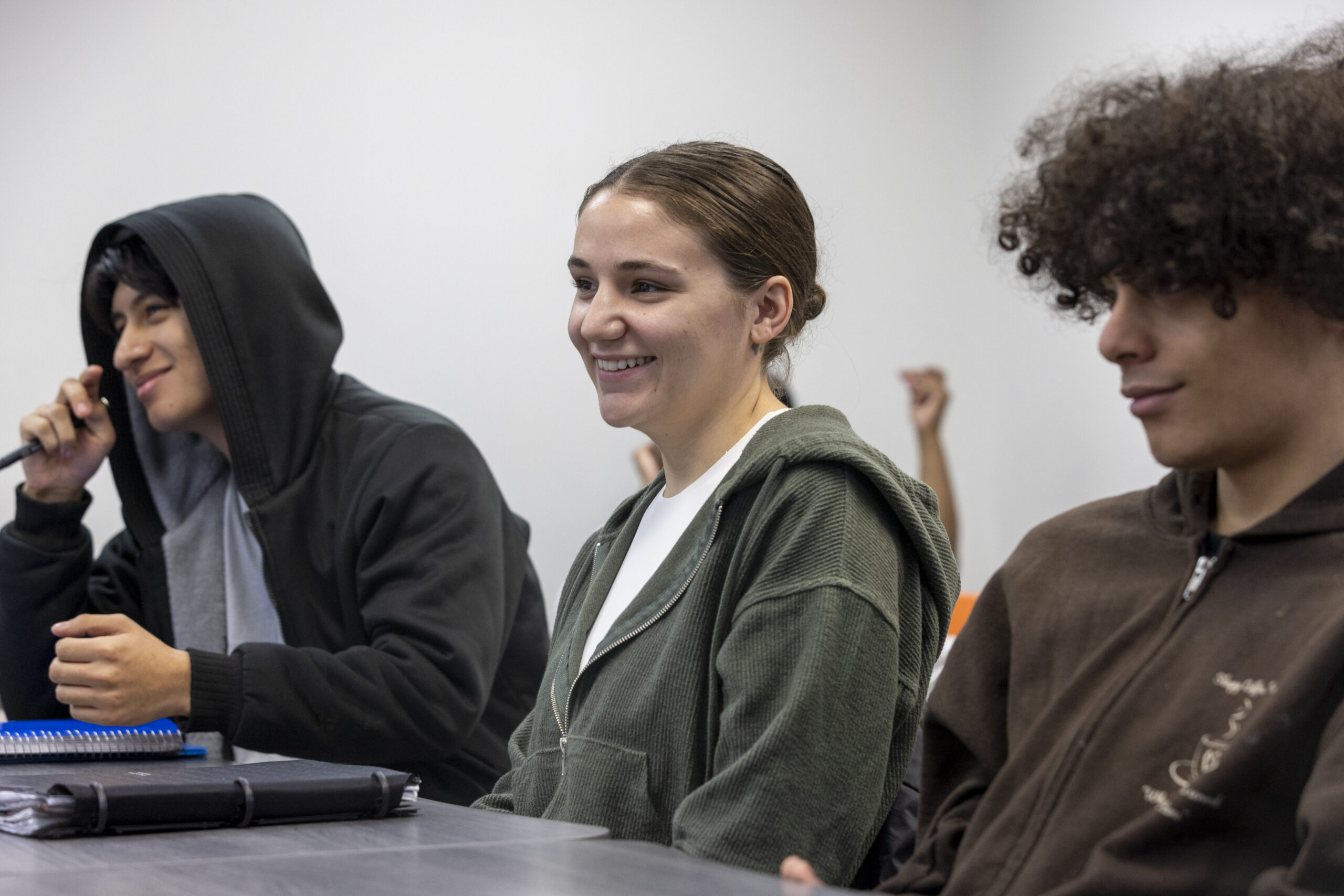 group of 3 students in classroom smiling