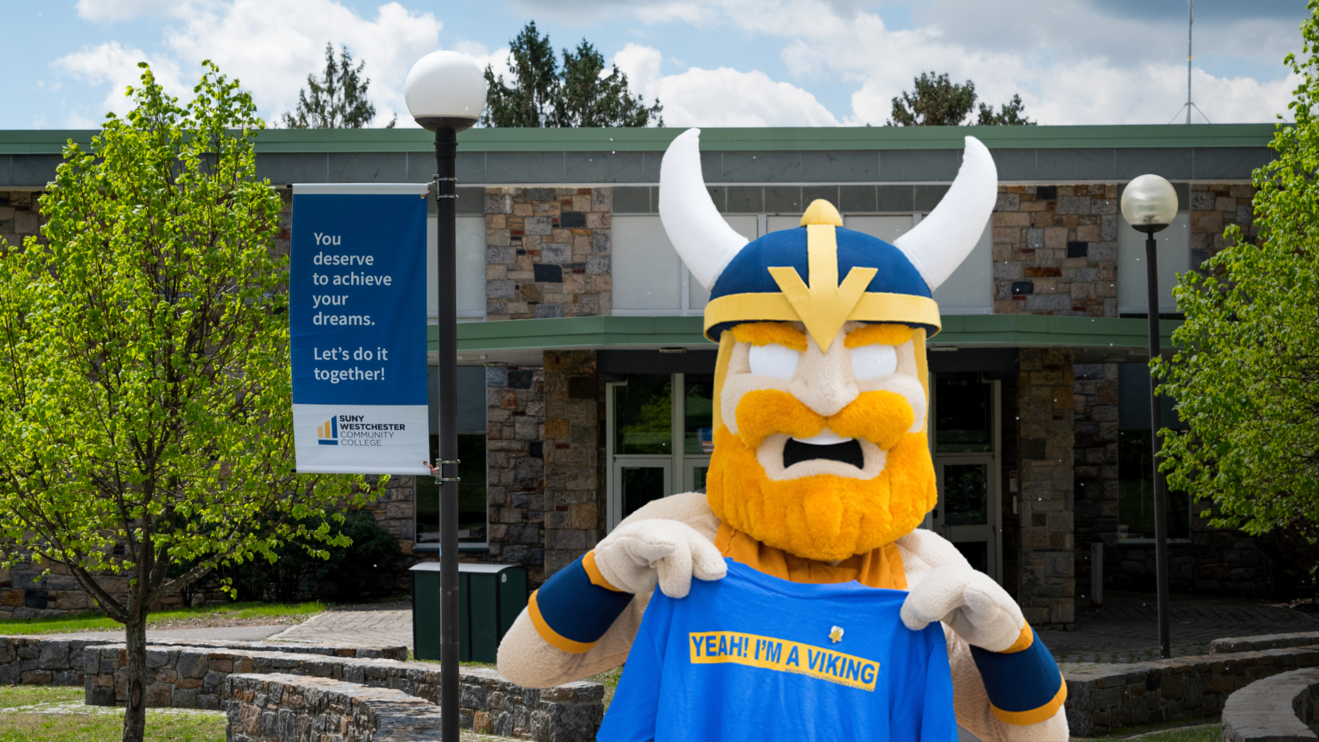 Chester mascot at SUNY Westchester Valhalla with slogan on t-shirt and sign