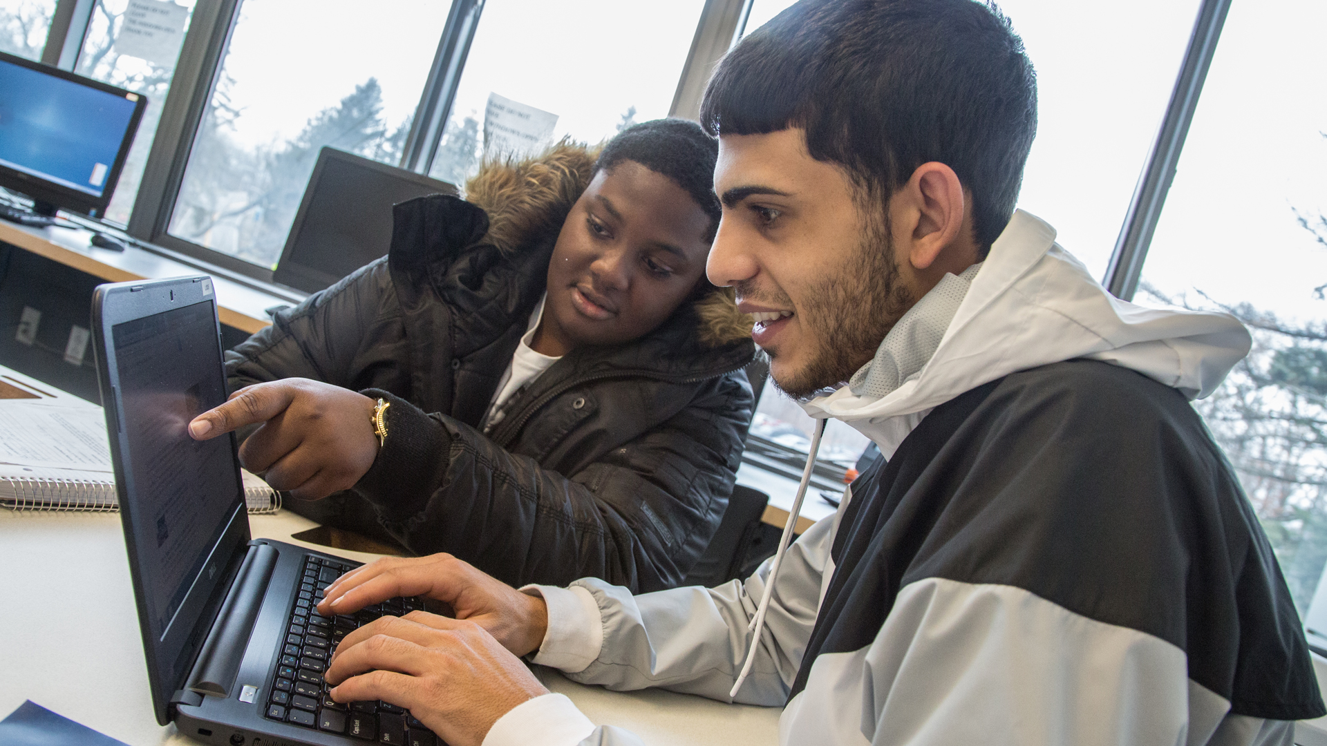 Students using a laptop in the library